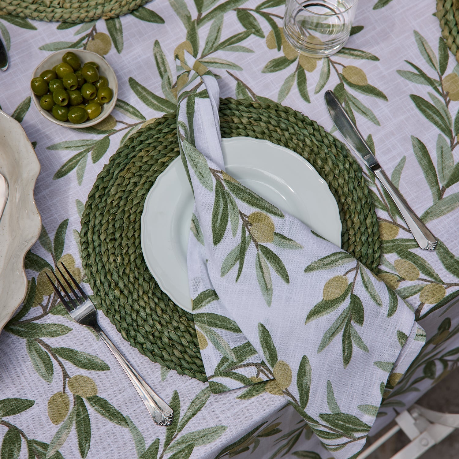 Madras Link Braided Round Placemat 33cm Olive - styled on a set dining table
