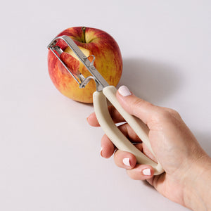SVNA swivel peeler side view — ergonomic non-slip cream handle